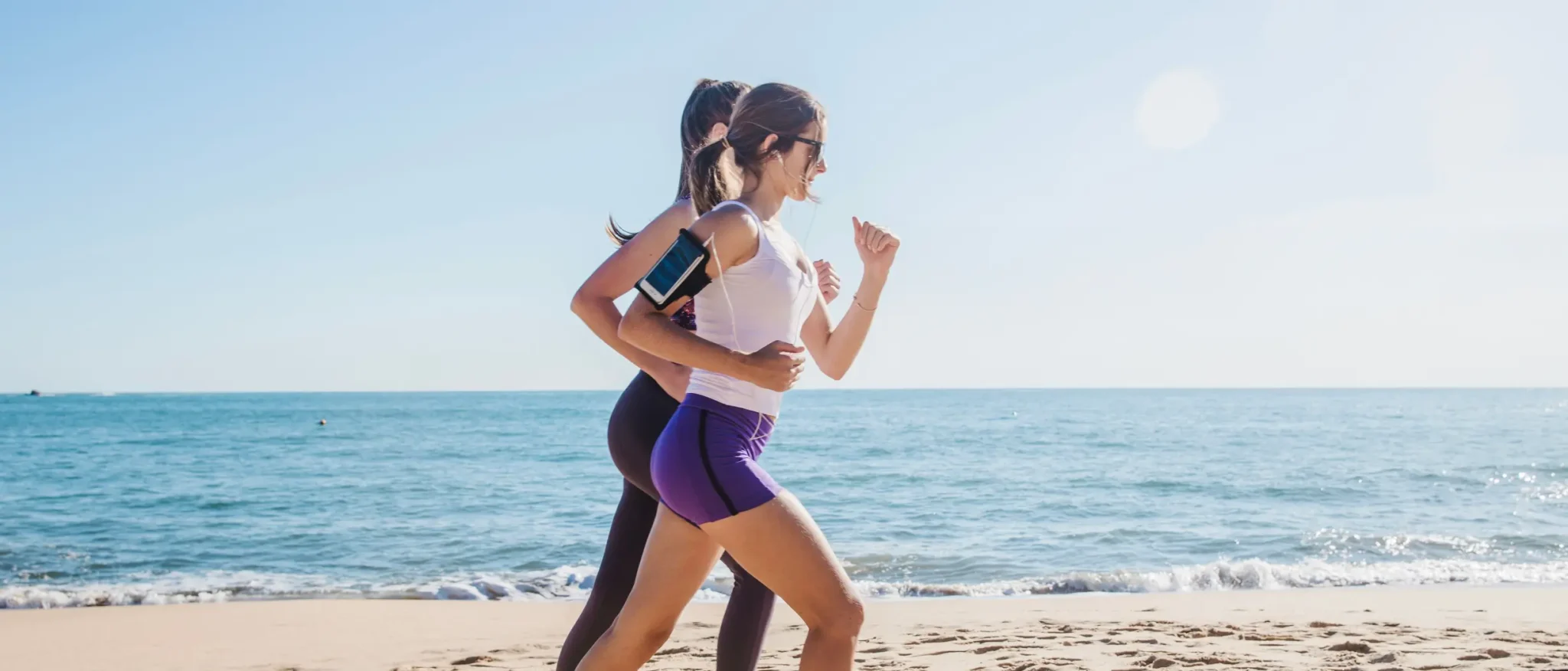 Woman running on the beach, feeling energized and healthy
