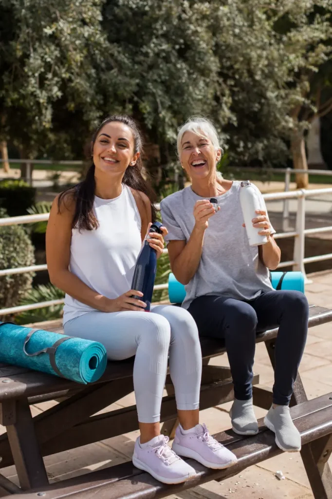 Friends doing yoga together in a park, feeling healthy and balanced